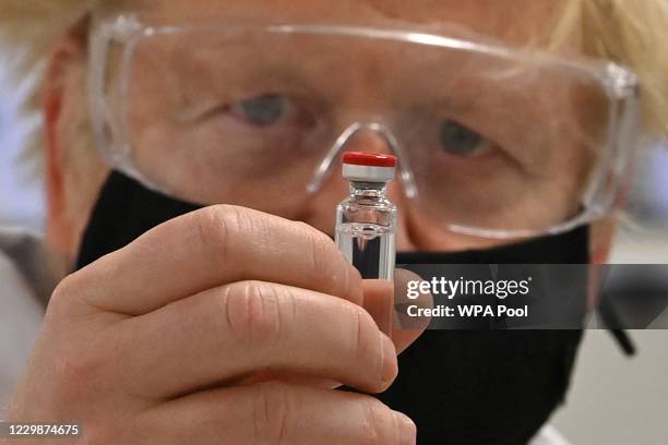 Prime Minister Boris Johnson poses for a photograph with a vial of the AstraZeneca/Oxford University COVID-19 candidate vaccine, known as AZD1222, at...