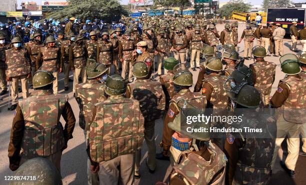 Police personnel in riot gear stand guard during day 5 of farmer protests at Singhu border on November 30, 2020 in New Delhi, India. Thousands of...