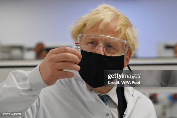 Prime Minister Boris Johnson poses for a photograph with a vial of the AstraZeneca/Oxford University COVID-19 candidate vaccine, known as AZD1222, at...