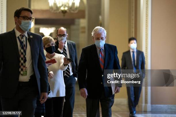 Senate Majority Leader Mitch McConnell, a Republican from Kentucky, center, wears a protective mask while walking to the Senate Floor at the U.S....