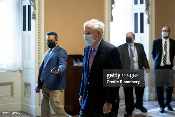 Senate Majority Leader Mitch McConnell, a Republican from Kentucky, center, wears a protective mask while walking to his office from the Senate Floor...