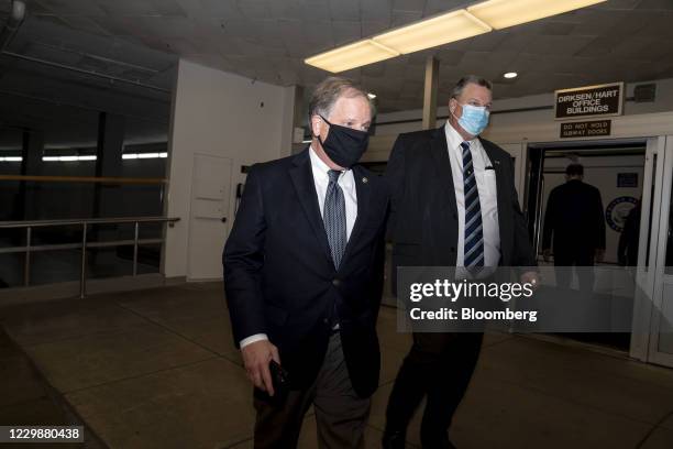 Senator Doug Jones, a Democrat from Alabama, left, and Senator Jon Tester, a Democrat from Montana, wear protective masks while walking through the...