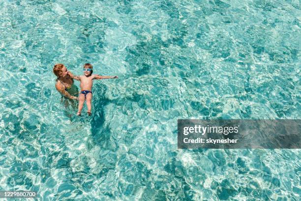 über blick auf glückliche alleinerziehende mutter und sohn im schwimmbad. - learning to swim stock-fotos und bilder