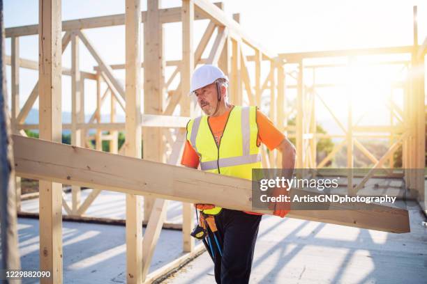 costruttore che lavora su casa di legno - construction material foto e immagini stock