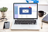 Email message inbox notification on laptop screen, business background