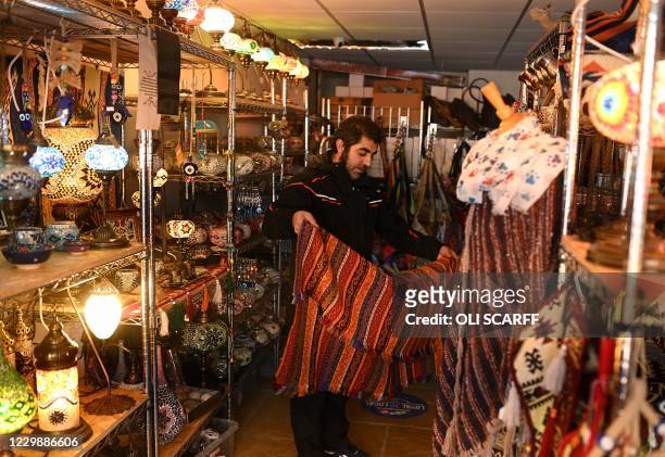 Remzi Sasma, owner of an independent emporium shop, prepares their stock ahead of reopening in Hebden Bridge, northern England on December 1 after...