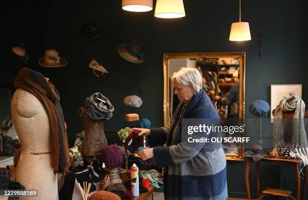 Milliner Chrissie King prepares their shop, Hat Therapy, ahead of reopening in Hebden Bridge, northern England on December 1 after having had to...