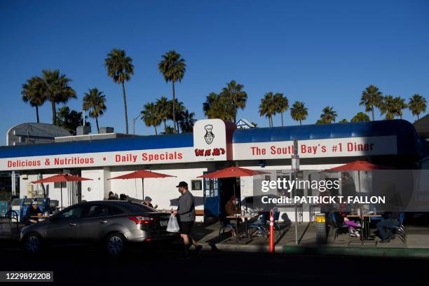 People eat breakfast outside at "Eat At Joe's", which has remained open for outdoor dining in defiance of reimposed Los Angeles County Covid-19...