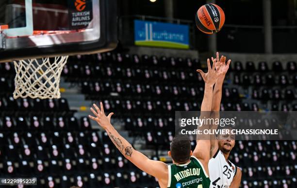 S French player William Howard passes the despite Panathinaikos' Greek player Konstantinos Mitoglou during of the Euroleague basket-ball match...