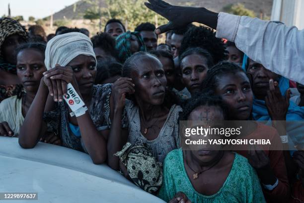 Ehiopians, who fled the Ethiopia's Tigray conflict as refugees, wait for food distribution in front of a warehouse at Um Raquba refugee camp in...