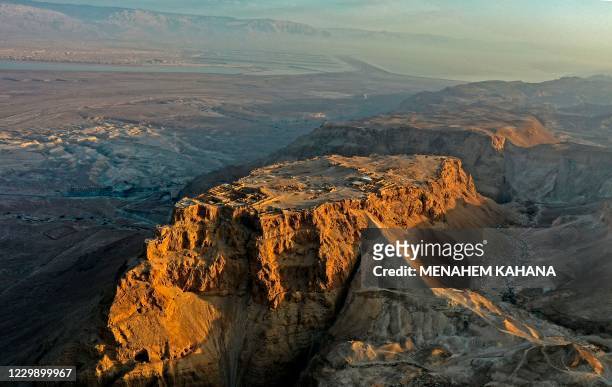 Picture taken on December 01 shows the ancient hilltop fortress of Masada in the Judean desert, with the Dead Sea pictured in the background. -...