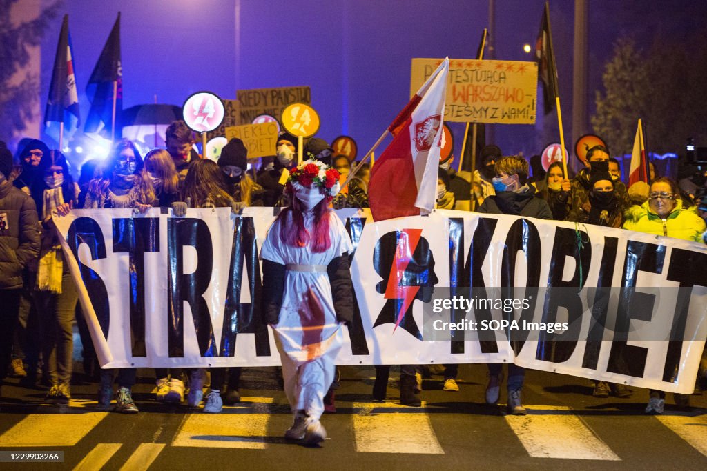Protesters hold a banner and placards during the Women's...