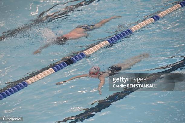 People swim laps in the indoor pool at Kensington Leisure Centre in London on December 2, 2020 as England emerges from a month-long lockdown to...