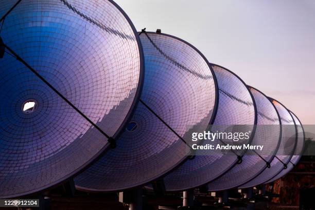 solar thermal power station with parabolic dish reflector at sunrise, australia - telecommunications equipment stock pictures, royalty-free photos & images
