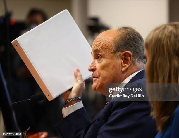 President Donald Trump's personal attorney Rudy Giuliani speaks as Jenna Ellis, a member of the president's legal team looks on at an appearance...