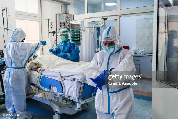 Medical personnel wear personal protective equipment as they assist a critical patient infected with coronavirus inside the Intensive Critical Unit...