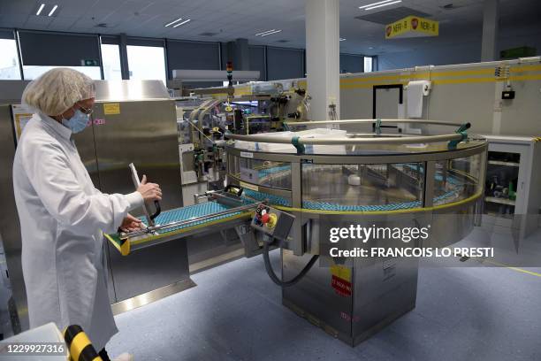 An employee works on a production line at the factory of British multinational pharmaceutical company GlaxoSmithKline in Saint-Amand-les-Eaux,...