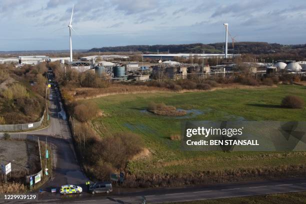 An aerial view shows a police vehicle forming cordon with a damaged silo seen in the background at a waste water treatment plant in Avonmouth, near...