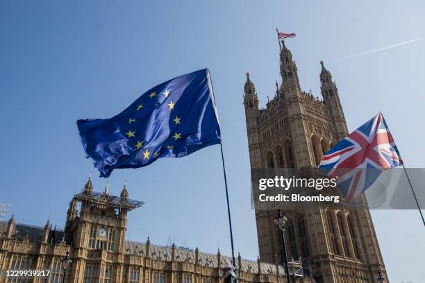 Flag of the European Union , left, flies with a Union flag, also known as a Union Jack, near the Houses of Parliament in London, U.K., on Monday,...