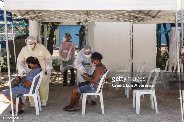 Patients wait to receive instructions from health workers before a COVID-19 testing at the Emergency Care Unit Colubandê on December 4, 2020 in Sao...