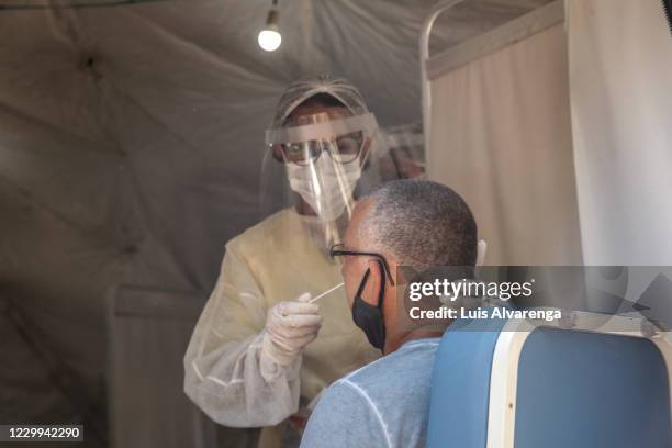 Health worker performs a COVID-19 testing at the Emergency Care Unit Colubandê on December 4, 2020 in Sao Goncalo, Brazil. The State Department of...