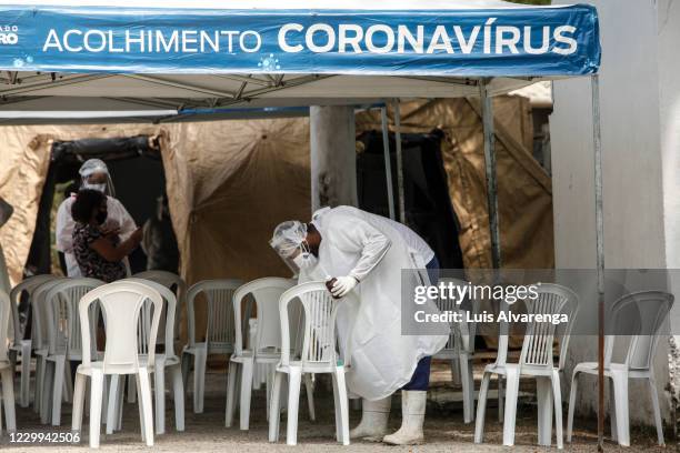 Health worker disinfects a chair as patients wait to receive instructions before a COVID-19 testing at the Emergency Care Unit Colubandê on December...
