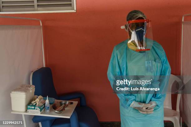 Health worker from the Alberto Torres hospital wearing PPE waits to perform COVID-19 testings on December 4, 2020 in Sao Goncalo, Brazil. The State...