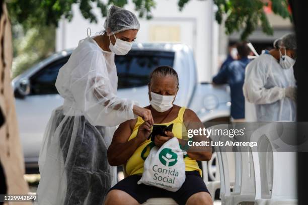 Patient receives instructions from a health worker before a COVID-19 testing at the Emergency Care Unit Colubandê on December 4, 2020 in Sao Goncalo,...