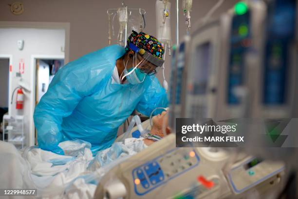 Healthcare worker Demetra Ransom comforts a patient in the Covid-19 ward at United Memorial Medical Center in Houston, Texas on December 4, 2020.