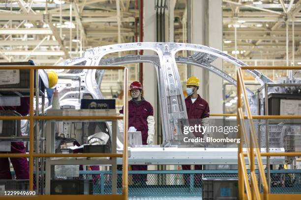 Employees monitor an assembly line during a media tour of the Nio Inc. Production facility in Hefei, Anhui province, China, on Friday, Dec. 4, 2020....