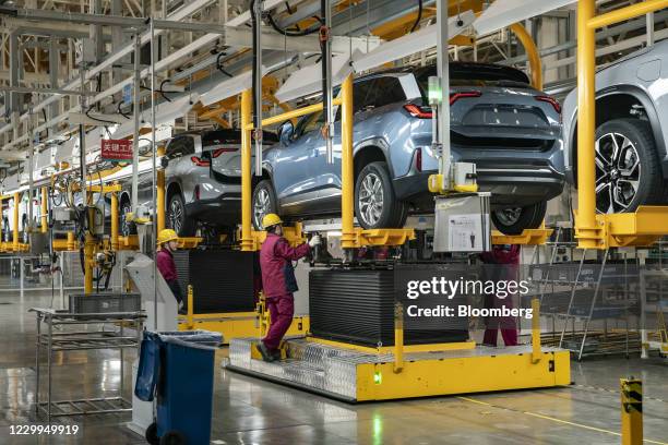 Employees install batteries onto an electric sport utility vehicle during a media tour of the Nio Inc. Production facility in Hefei, Anhui province,...