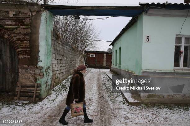 Woman walks by the street, on December 5, 2020 in Staritsa, located on the Volga river, 250 kilometers northwest from Moscow, in Tver oblast, Russia....