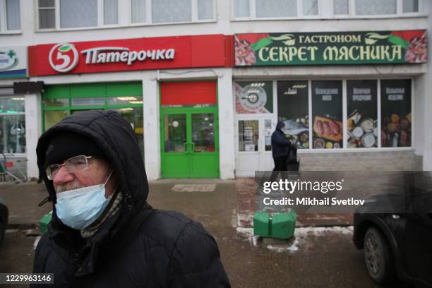 Man wearing a protective face mask walks the street, on December 5, 2020 in Staritsa, located on the Volga river, 250 kilometers northwest from...