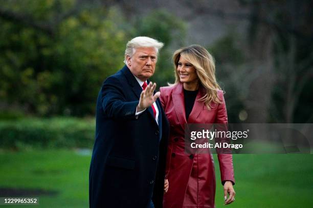 President Donald Trump waves as he walks with First lady Melania Trump as they depart on the South Lawn of the White House, on December 5, 2020 in...