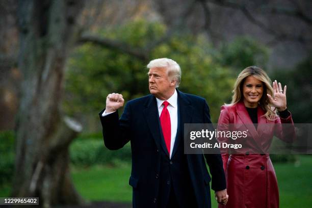 President Donald Trump pumps his fist and First lady Melania Trump waves as they depart on the South Lawn of the White House, on December 5, 2020 in...