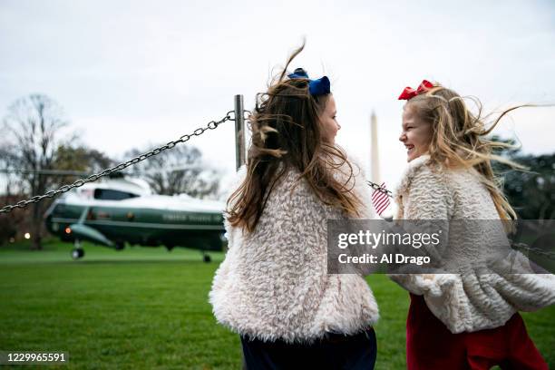 Viven Young left, and Madeline Young from Nashville, Tenn., laugh as they watch Marine One, carrying U.S. President Donald Trump, depart on the South...