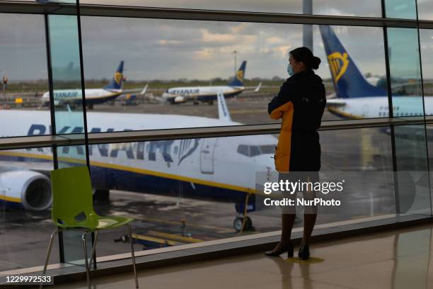 Member of Ryanair cabin crew looks out of the window at Ryanair planes grounded at Dublin Airport, during the coronavirus lockdown level 3. The...
