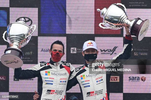 Winners French driver Sebastien Ogier and his co-driver Julien Ingrassia hold their trophies on the podium after winning the FIA World Rally...