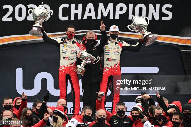 French driver Sebastien Ogier and his co-driver Julien Ingrassia pose with Toyota team principal Tommi Makinen of Finland and staff members after...