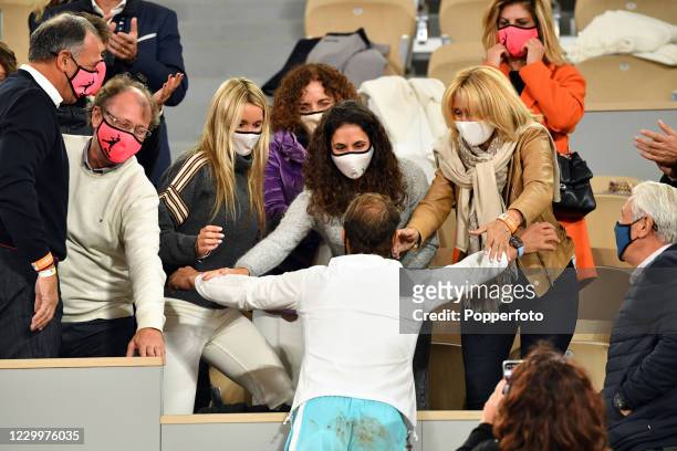 Rafael Nadal of Spain celebrates with his friends and family, all wearing face masks, after defeating Novak Djokovic of Serbia in the men's singles...