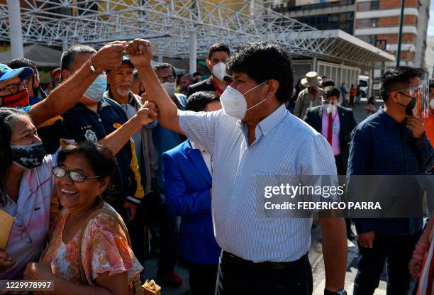 Bolivian ex-president Evo Morales, wearing a face mask, greets followers upon arrival to visit a polling station in downtown Caracas, on December 6...