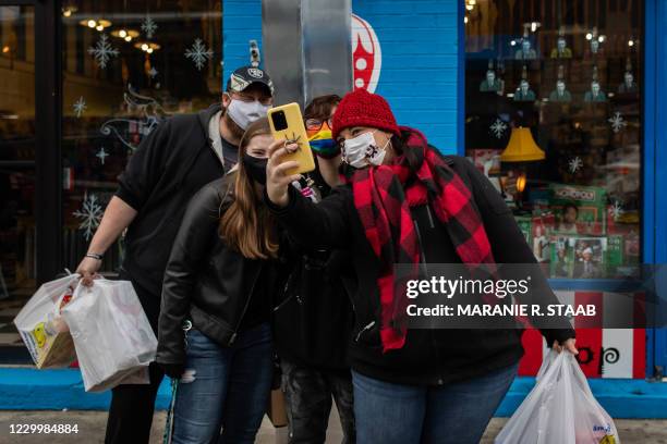 People stop to take pictures with a monolith outside of Grandpa Joes Candy Shop in the Strip District area of Pittsburgh, Pennsylvania on December 6,...