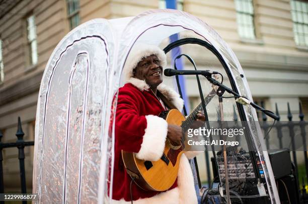 Antonio Tony Covay, dressed as Santa Claus, performs holiday songs, at the Downtown Holiday Market, on December 6, 2020 in Washington, DC. Covay is...