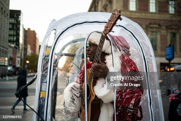 Antonio Tony Covay, dressed as Santa Claus, performs holiday songs, at the Downtown Holiday Market, on December 6, 2020 in Washington, DC. Covay is...