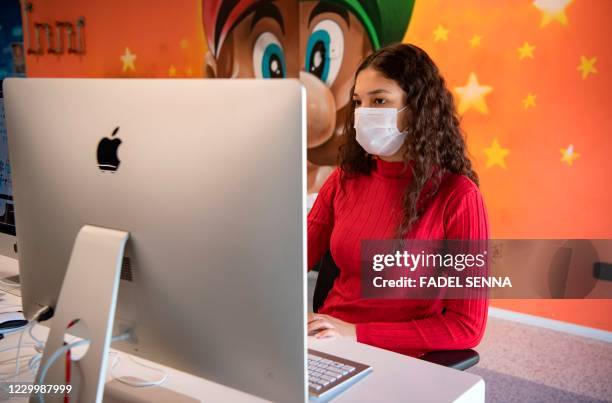 Student, mask-clad due to the COVID-19 coronavirus pandemic, uses a computer at a lab room at the "1337" information technology training centre in...