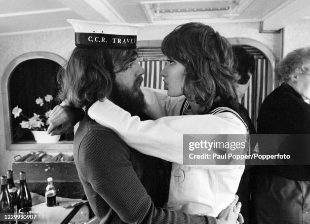 American musician Doug Clifford of Creedence Clearwater Revival photographed with a young woman during a boat trip on the River Thames during their...