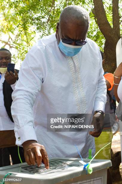 Former Ghana's President John Dramani Mahama casts his ballot as he votes for the presidential and parliamentary election at an open-air polling...