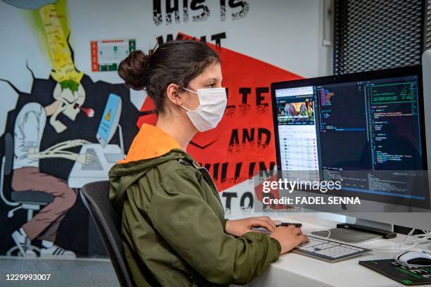 Student, mask-clad due to the COVID-19 coronavirus pandemic, uses a computer at a lab room at the "1337" information technology training centre in...