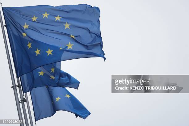 European Union flags fly outside the European Commission building in Brussels, on December 7, 2020.