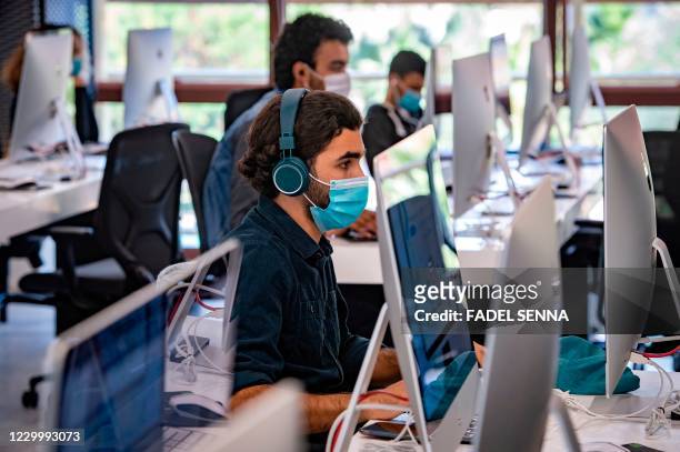 Student, mask-clad due to the COVID-19 coronavirus pandemic, uses a computer at a lab room at the "1337" information technology training centre in...